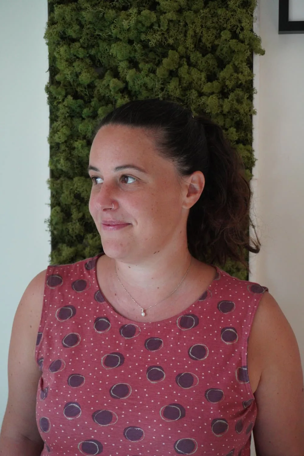 Alice Mariani, psicologa, davanti alla parete di muschio